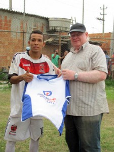 Miller, do Raça, jogou muito e recebeu a camisa-prêmio das mãos do presidente da Liga de Nova Iguaçu, Luiz Carlos Pina (Foto: Jaílza Ribeiro/Divulgação)